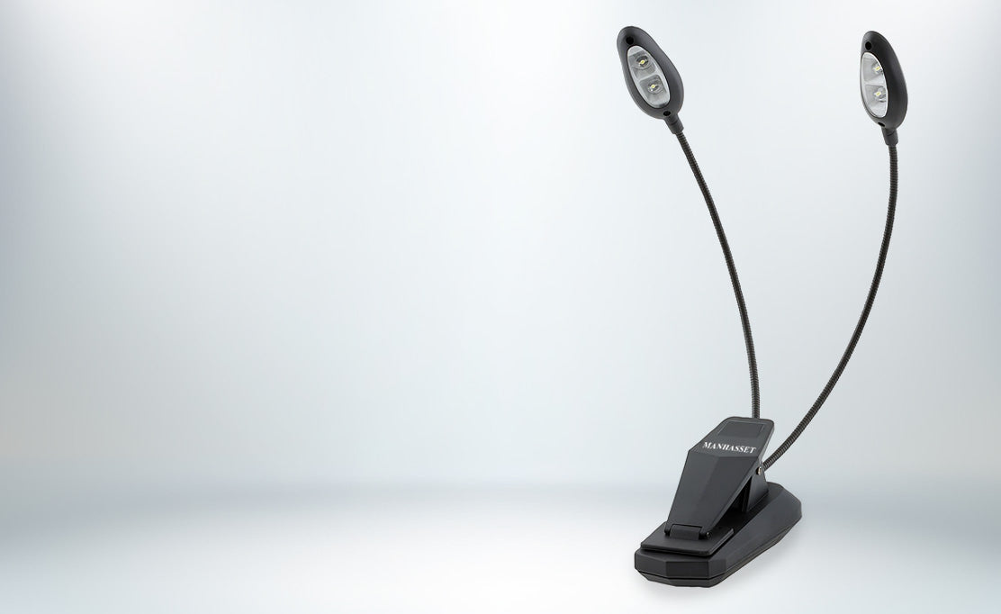 A black clip-on dual LED reading light with two flexible gooseneck lamps, shown on a clean light gray gradient background.